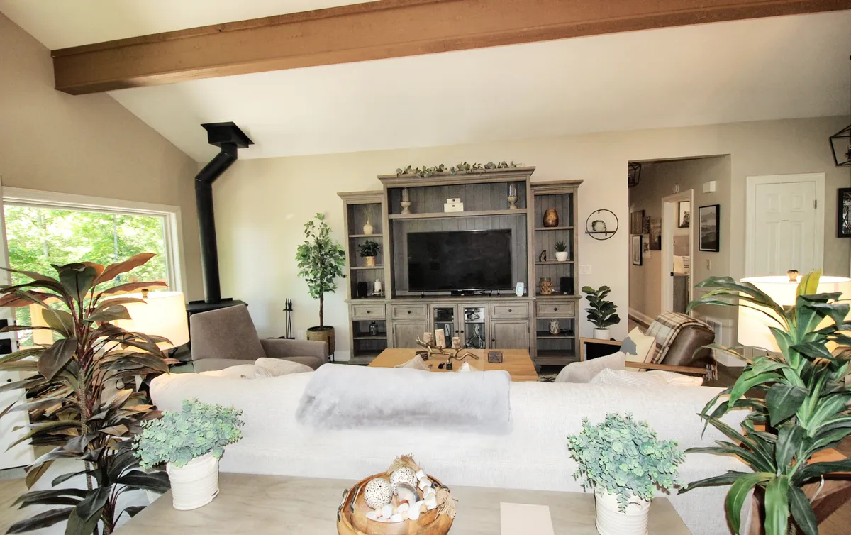 A spacious living area with a large entertainment unit, comfortable seating, and decorative plants, designed for relaxing evenings, socializing, and cozy movie nights after a day out exploring.