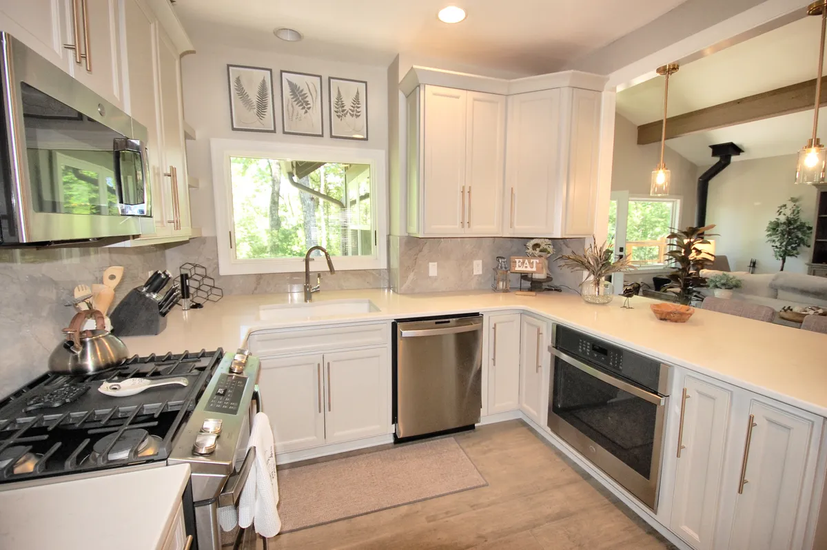 A bright, functional kitchen with a central island, large window letting in natural light, and artful decor, creating a warm setting for preparing meals or sharing wine after exploring nearby attractions.